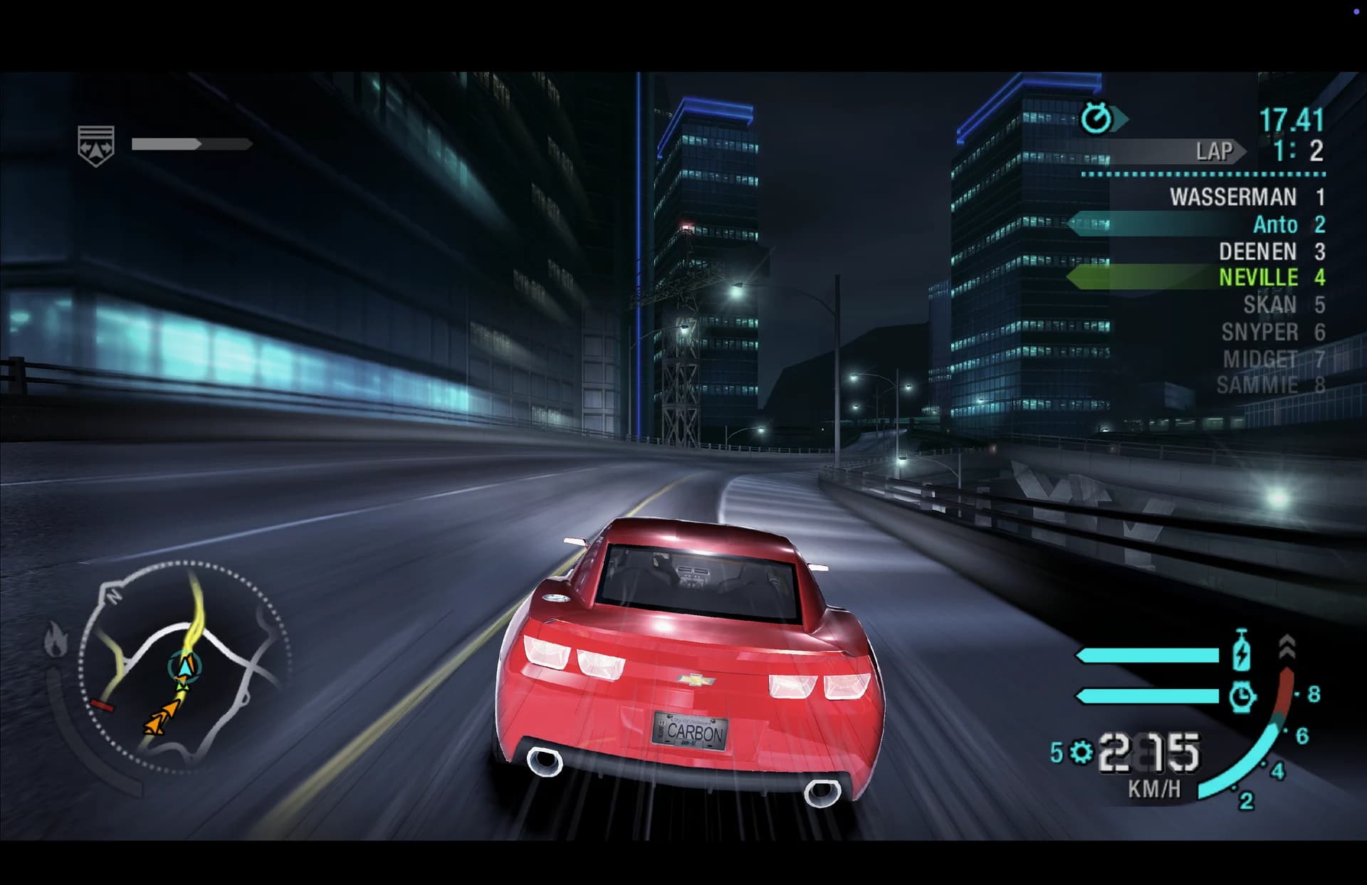 A red Chevrolet Camaro races through a city at night in Need for Speed: Carbon. The race position, speedometer, and minimap are visible.